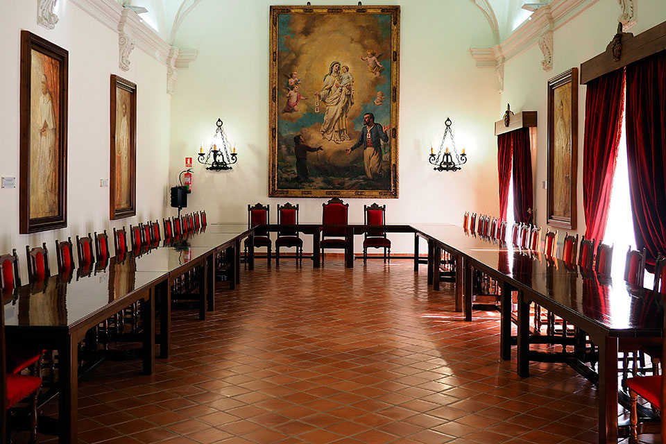 Sala capitular con mesa en forma de herradura y cuadros de Nati Cañada