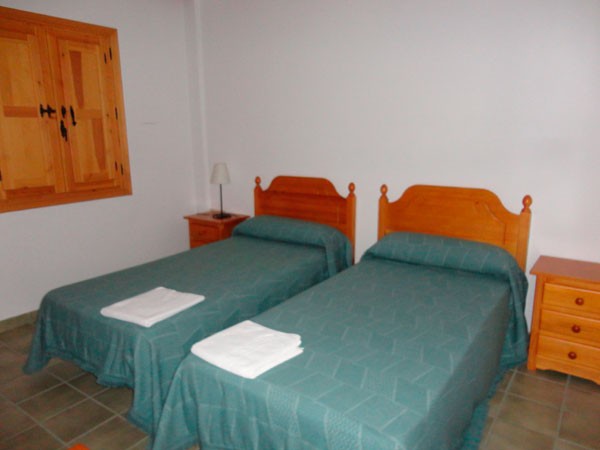 Habitación con dos camas de uno de los apartamentos del Monasterio El Olivar