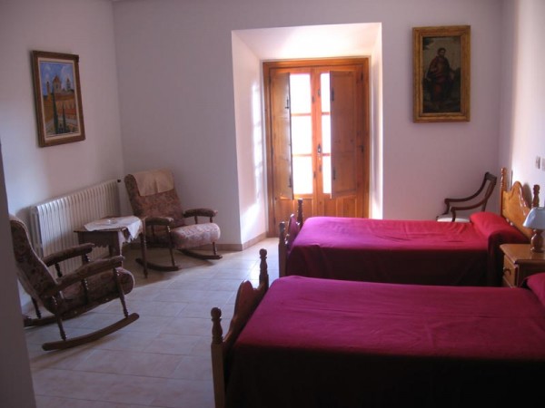 Habitación con dos camas y rincón de lectura Hospedería Monasterio el Olivar